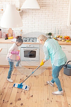 Top view of mother and her foster child cleaning the kitchen