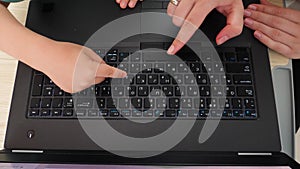 Top view of mother and little son pressing buttons on laptop keyboard. Child learning using computers and laptops