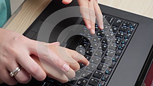 Top view of mother showing her child how to use computer keyoard. Boy with parent learnign and studying on laptop