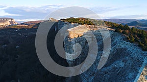 Top view of mountain landscape with green fields in evening sun. Shot. Beautiful mountain area with stone rock green