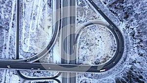 Top view of the movement of cars through a busy intersection with an overpass. Time lapse