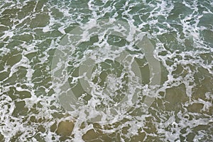 Top view on moving sea water with waves and foam, texture background pattern