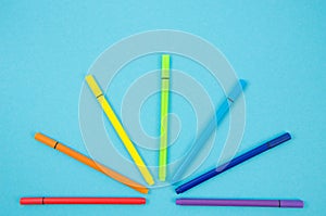Top view multi-colored Felt Tip Pens on blue background. Rainbow colors markers. Back to school concept