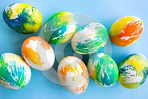 Top view of multicolored Easter eggs on a blue background. Happy Easter card