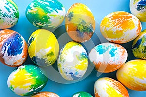 Top view of multicolored Easter eggs on a blue background. Happy Easter card