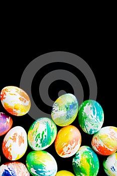 Top view multicolored eggs on a black isolated background. Happy Easter card