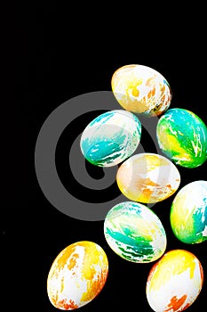 Top view multicolored eggs on a black isolated background. Happy Easter card