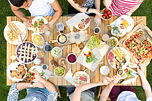 Top view on multicultural group of friends eating grilled food d