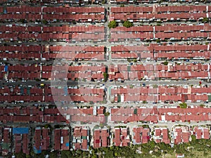 Top view of multiple blocks of townhouses with red steel roofs. A crowded subdivision in Imus, Cavite, Philippines