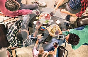 Top view of multiracial friends tasting red wine at bar winery