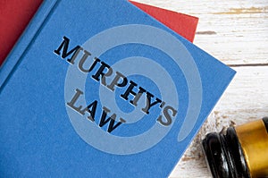 Top view of Murphy's Law book on wooden table with gavel background