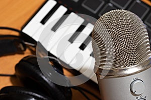 Top view of music producer work space. Table with professional headphones, synthesizer keyaboard and mic. Copy space