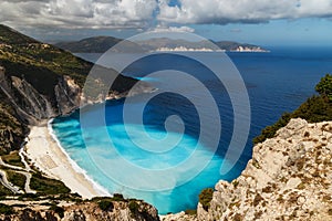 A top view at Myrtos Beach and fantastic turquoise and blue Ionian Sea water. Aerial view, summer scenery of famous and