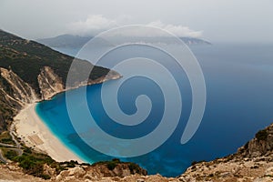 Top view at Myrtos Beach from road during bad weather conditions, thunderstorm and rain, with low dark clouds over sea
