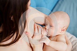 top view. a naked mother feeds the baby with breast milk. the breastfeeding.