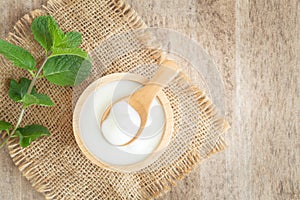 Top view of natural greek yogurt in cup  old wooden table background. Yogurt is delicious tasty and healthy