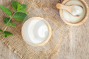 Top view of natural greek yogurt in cup  old wooden table background. Yogurt is delicious tasty and healthy