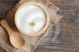 Top view of natural greek yogurt in cup on old wooden table background. Yogurt is delicious tasty and healthy