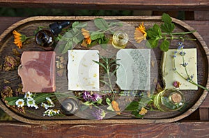 Top view of natural handmade skincare. Organic soap bars with plants extracts and oil bottles