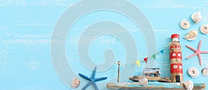 Top view of Nautical concept with sea life style objects as boat, driftwood beach lighthouse, seashells and starfish over wooden