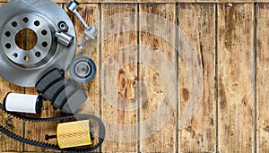 Top view of new car parts brake disc, brake pads, belt, filter on an old wooden table. To the right is an empty space