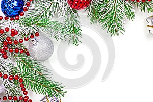 Top view of New Year and Christmas decorations with green fir tree branches as a frame with copy space for greeting card