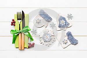 Top view of New Year dinner on wooden background. Festive cutlery on napkin with christmas decorations and toys. Close up of