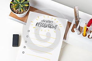 Top view new year`s resolutions checklist on white paper note on modern office stationery on white table.pencil, notepad,ruler,pe