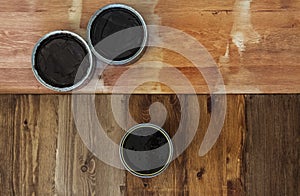 Top view on a newly opened can of wax, varnish, oil, paint on a freshly painted wooden surface. Several wood coating