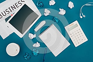 top view of newspaper, digital tablet with blank screen, blank notebook and calculator