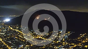 Top view, night and city with light, buildings and mountain with view, nature and forest blaze with danger. Cape Town