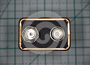 Top view of a nine volts battery type on a geometric background. Macro image