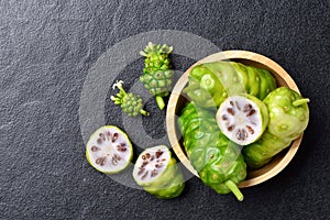 Top view of Noni or Morinda Citrifolia fruits with wooden bowl