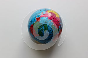 Top view of the North Pole on a miniature Earth globe on white surface