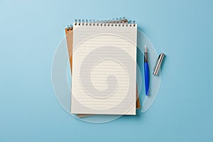 Top view of notebook and fountain pen on blue background