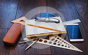 Top view of notebook, stationery, drawing tools and a few glasses. improvise.