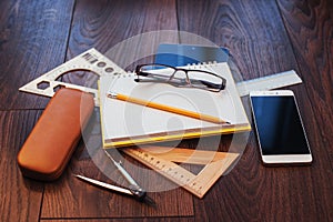 Top view of notebook, stationery, drawing tools and a few glasses. improvise.