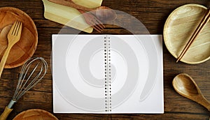 Top view notebook to write recipe of menu and wooden kitchen utensils cooking tools on wood table background , a overhead or flat