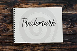 Top view of notebook written with Trademark on wooden background