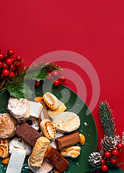 Top view of Nougat christmas sweet,mantecados and polvorones with christmas ornaments on a plate. Assortment of christmas sweets