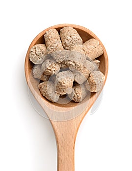 Top view of oats bran pellets in wooden spoon