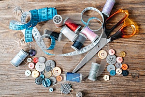 Top view of objects about Sewing equipment set on a wooden background. Sewing and tailoring concept.