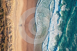 Top view of the ocean beach. Calm seascape with white foam and sand. Travel and leisure concept