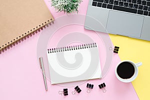 Top view office desk with laptop, blank empty notebooks and coffee cup on pastel color background.