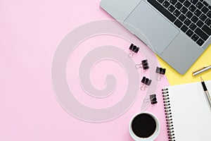 Top view office desk with laptop, blank empty notebooks and coffee cup on pastel color background.