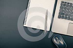 Top view of office desk with notebook pen and laptop