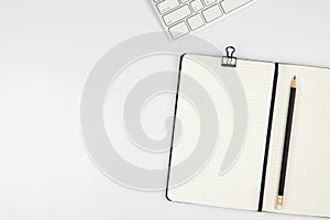 Top view of office desk with notebook and pencil