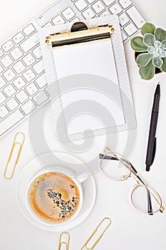 Top view of office desk. Table with keyboard, clipboard and office supplies. Flat lay home office workspace, remote work, distant