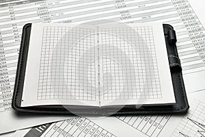 Top view of office employee`s desk - empty Notepad with blank pages and financial reports, analysis and accounting