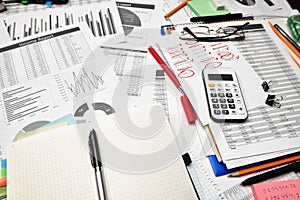 Top view of office employee`s desk - work with financial reports, analysis and accounting, tables and graphs, various office item